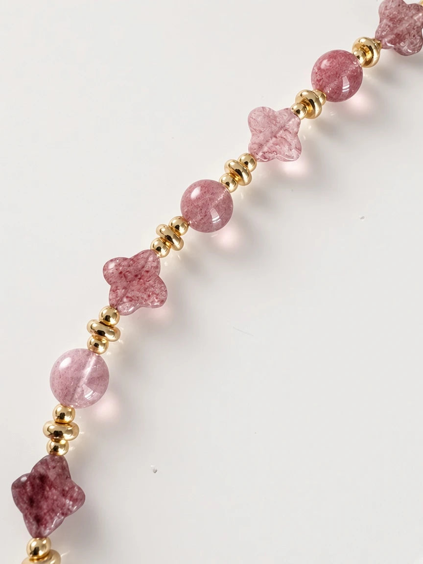 Hue La La Gems beaded necklace featuring pink gemstone spheres and flower-shaped carvings with gold-tone spacer beads.