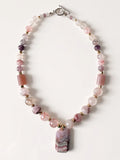 Hue La La Gems beaded statement necklace with pink gemstone beads, gold spacers, and a geometric banded pendant.