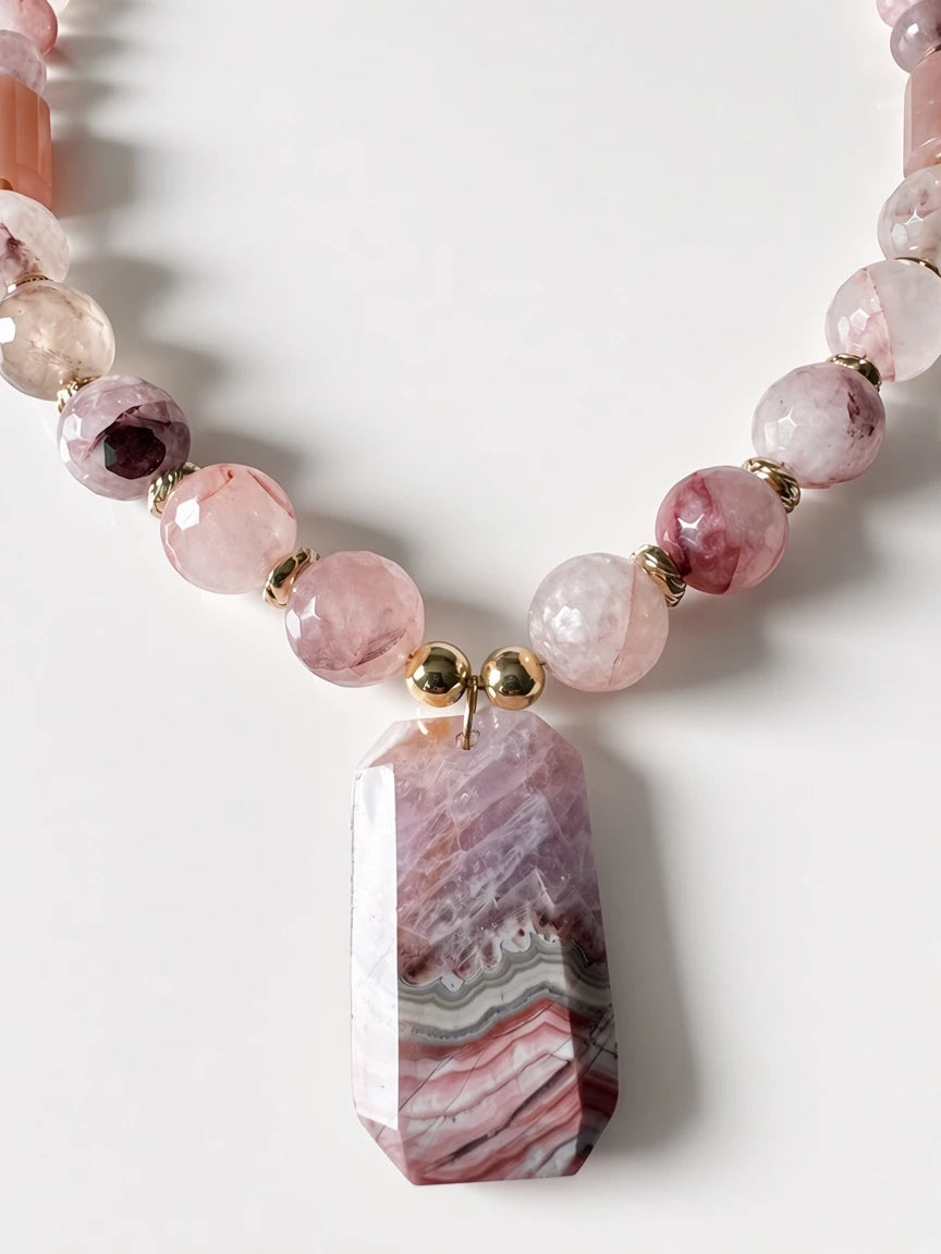 Hue La La Gems beaded statement necklace featuring pink gemstone beads, gold spacers, and a geometric banded pendant.