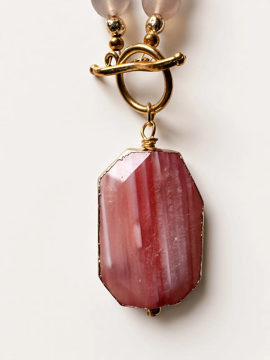 Hue La La Gems statement necklace featuring a faceted pink gemstone pendant with gold rim and toggle clasp