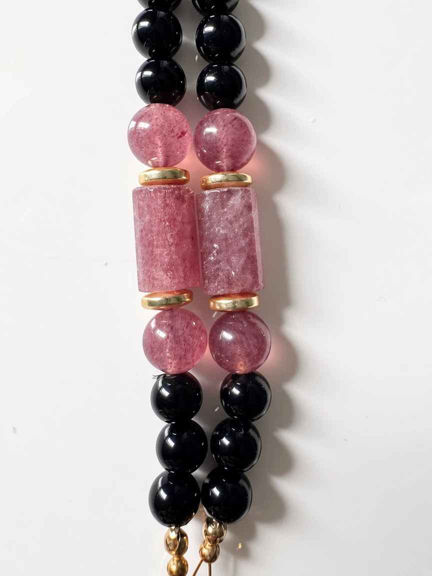 Hue La La Gems beaded necklace featuring polished black beads, pink quartz cylinders, and gold-tone spacers.