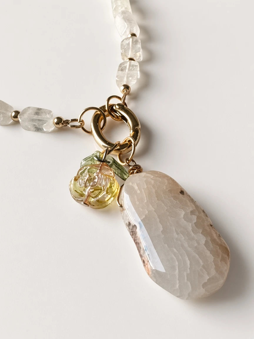 Hue La La Gems beaded necklace with clear quartz, gold-tone spacers, organic stone pendant, and floral charm.