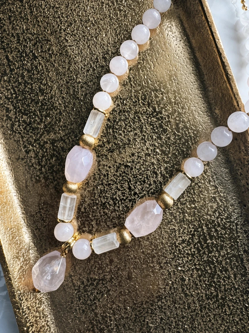 Hue La La Gems beaded necklace featuring rose quartz and clear quartz beads with gold-tone accents on a gold tray.