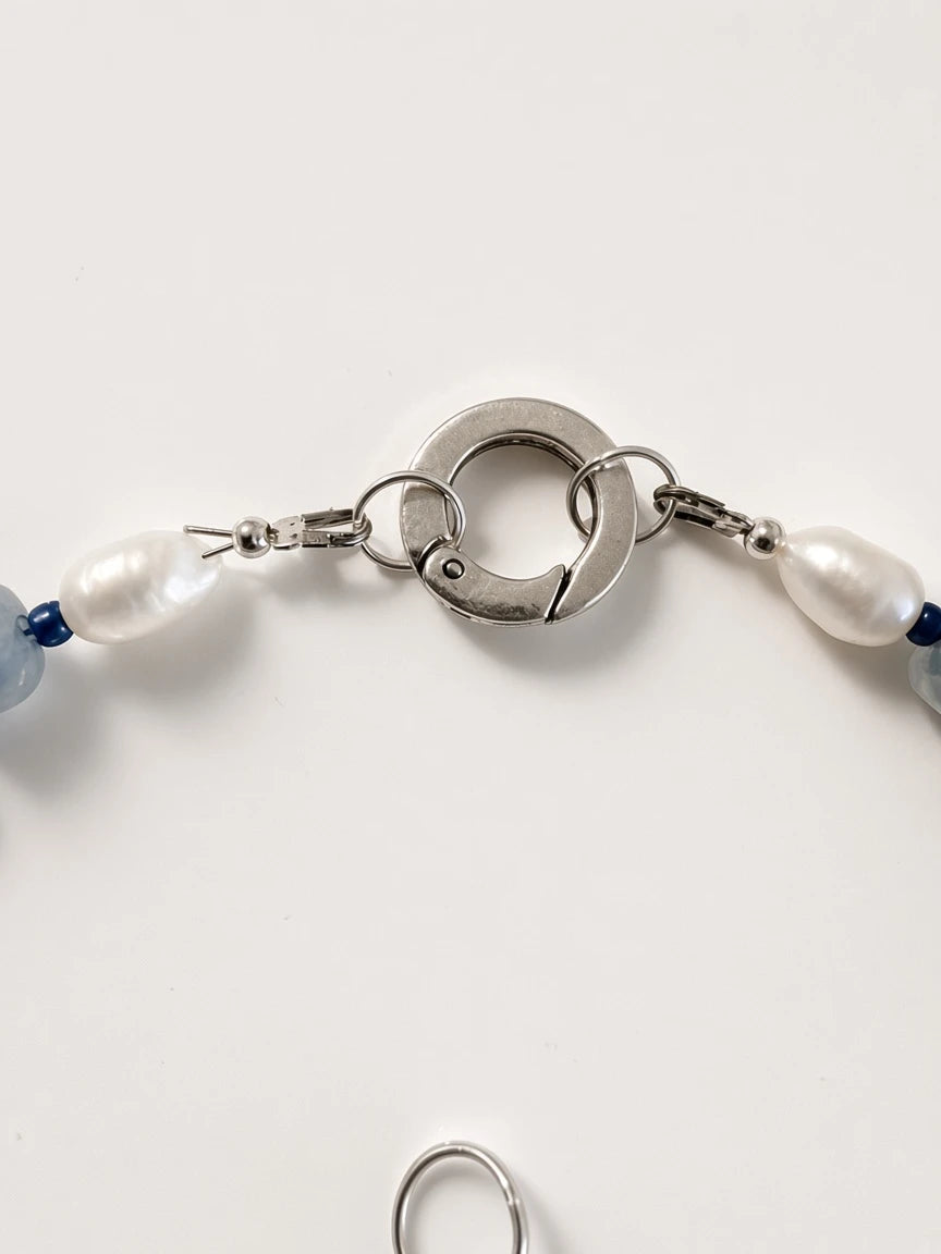 Hue La La Gems handcrafted necklace featuring a polished silver-tone circular clasp with freshwater pearl accents.
