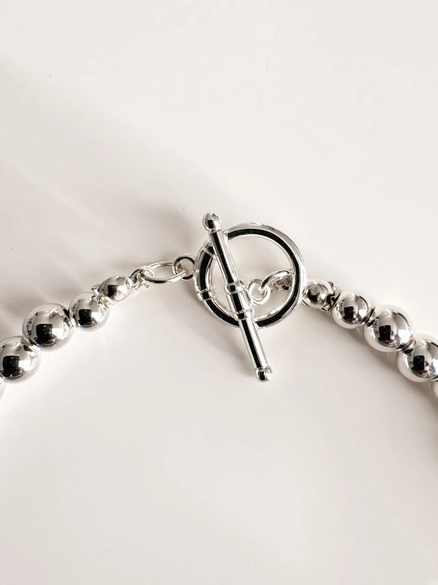 Hue La La Gems statement necklace featuring a polished silver-tone toggle clasp and matching metallic beads.