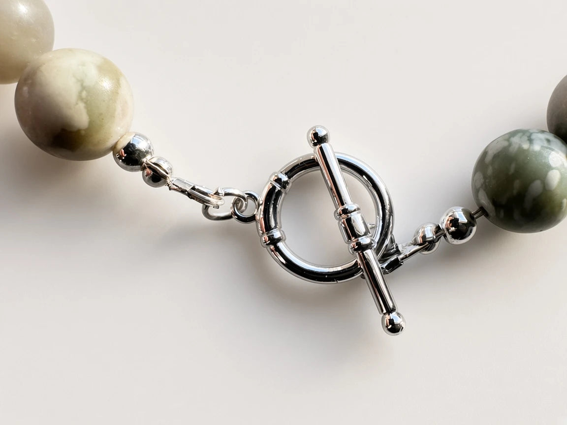 Hue La La Gems handcrafted statement necklace featuring sage and grey stone beads with a polished silver toggle clasp.