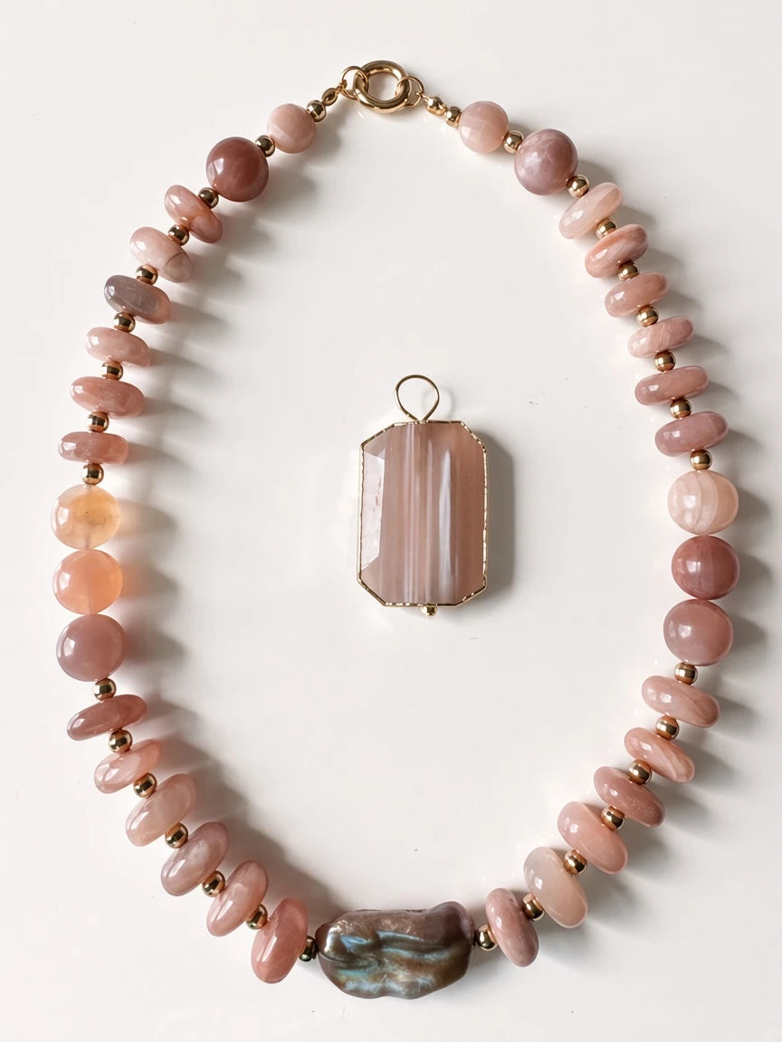 Hue La La Gems statement necklace with peach sunstone beads, gold spacers, a baroque pearl, and a rectangular pendant.