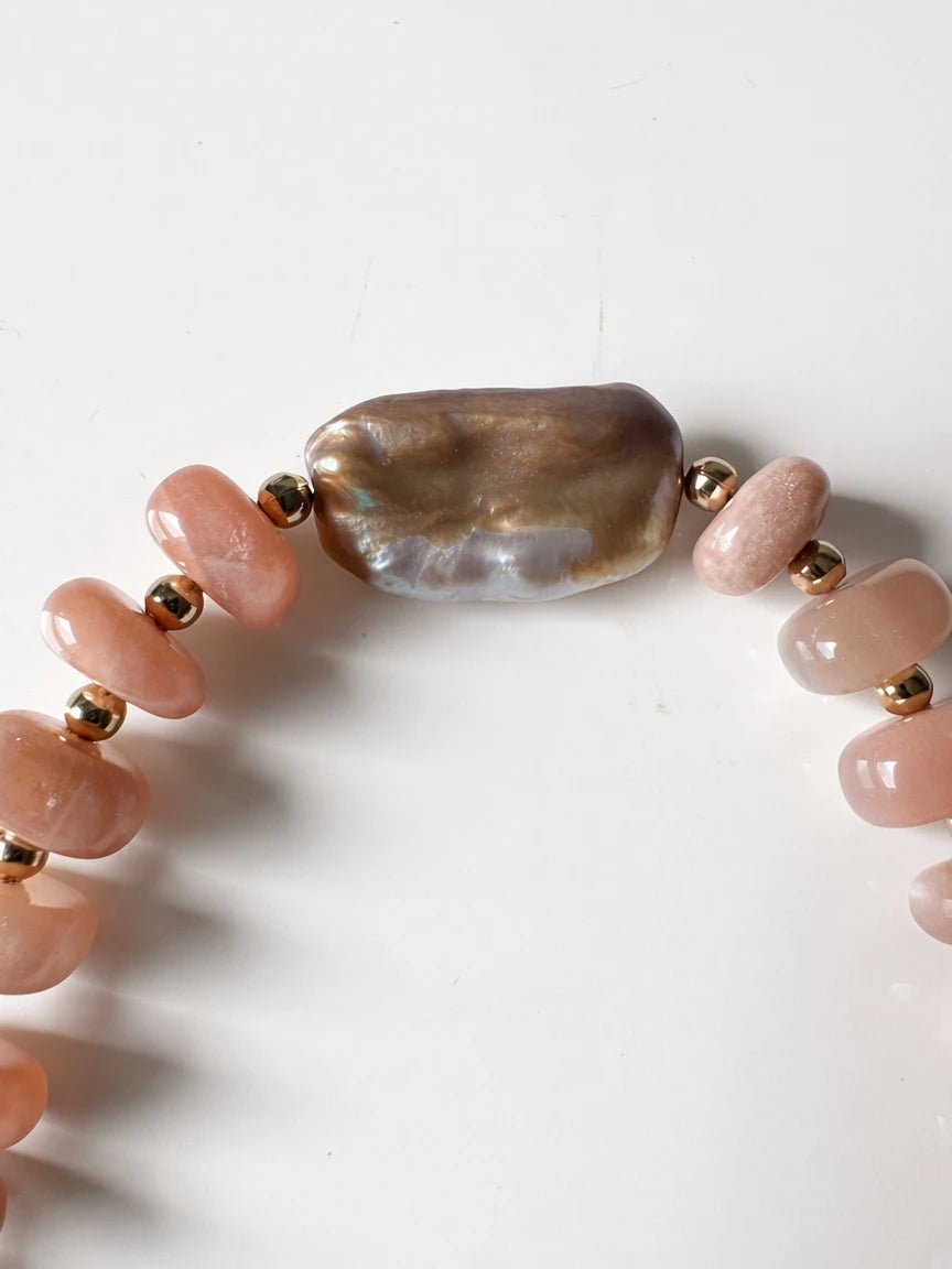 Hue La La Gems beaded necklace featuring smooth peach sunstone beads, gold-tone spacers, and an iridescent baroque pearl.