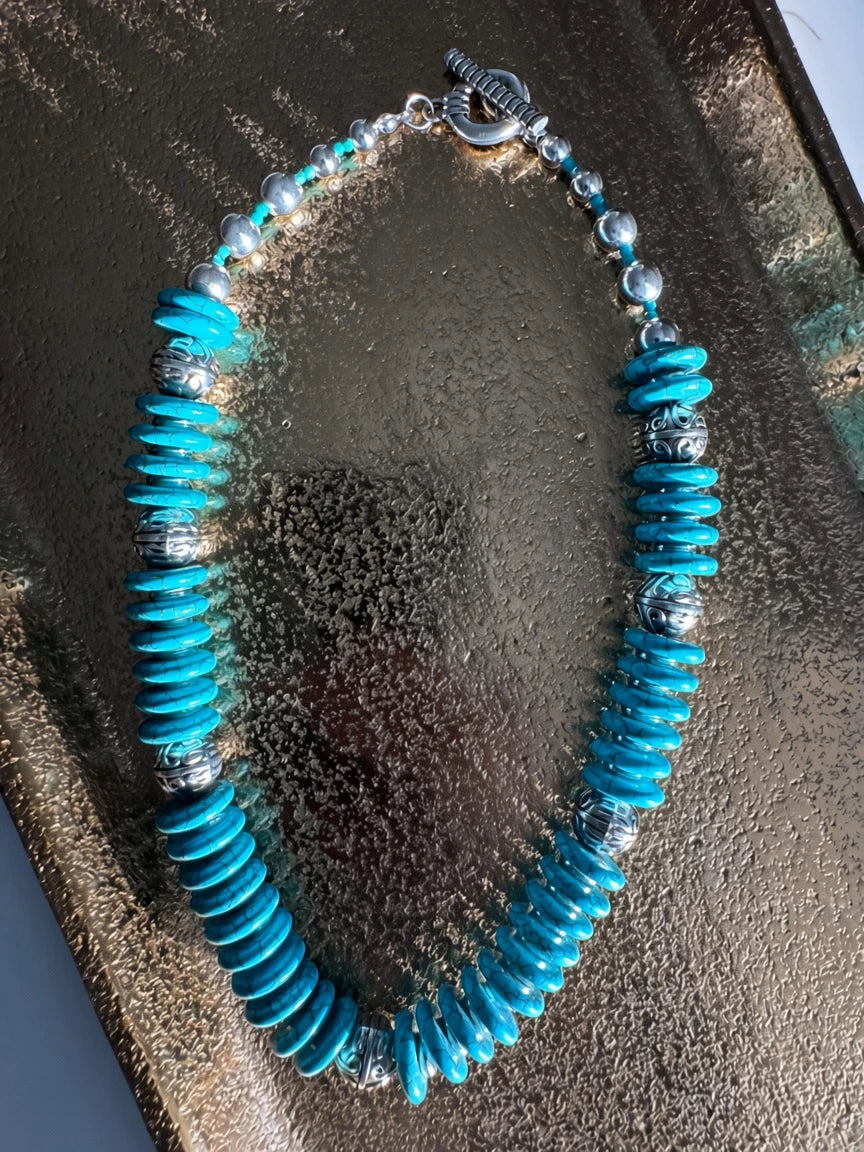 Hue La La Gems turquoise disc beaded statement necklace with intricate silver-tone metal spacers and a toggle clasp.