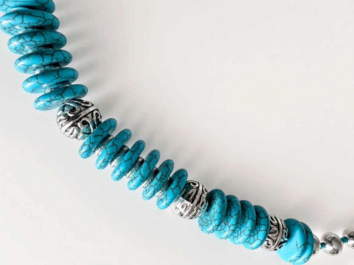 Hue La La Gems turquoise disc bead statement necklace with intricate silver-tone metal spacers on a white background