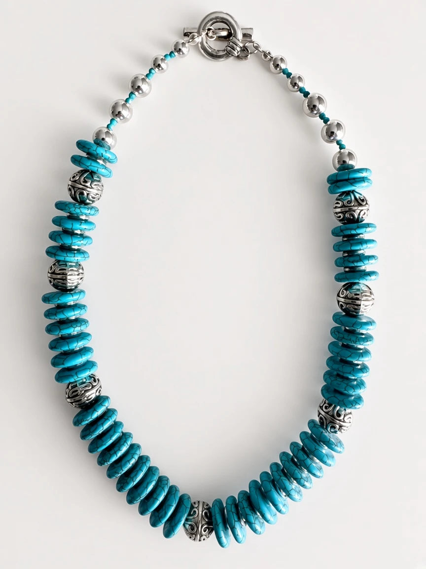 Hue La La Gems turquoise disc bead statement necklace with intricate silver-tone metal spacers and a toggle clasp.