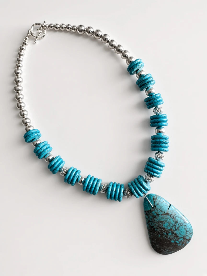 Hue La La Gems turquoise statement necklace with a teardrop pendant, disc beads, and silver-tone accents.