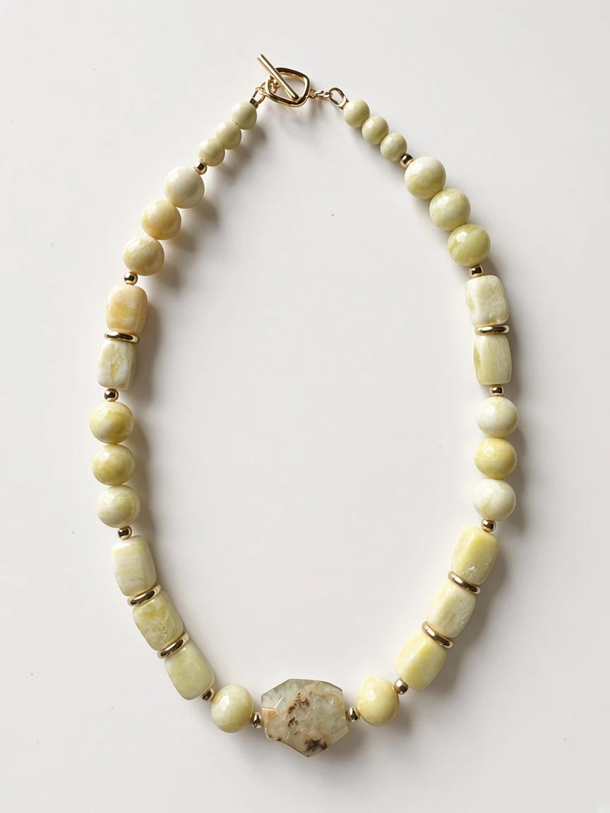 Hue La La Gems beaded statement necklace with pale yellow-green stones, gold-tone spacers, and heart toggle clasp.